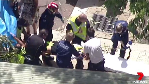 A student is carried on a stretcher after being freed from under the branch.