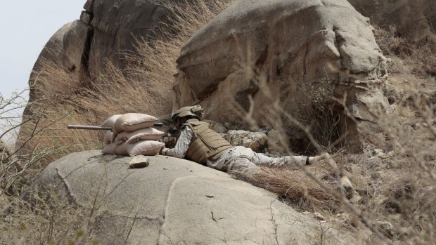 A Saudi soldier aims a machine-gun from behind a sandbag barricade on the border with Yemen in Jazan, Saudi Arabia, in April.