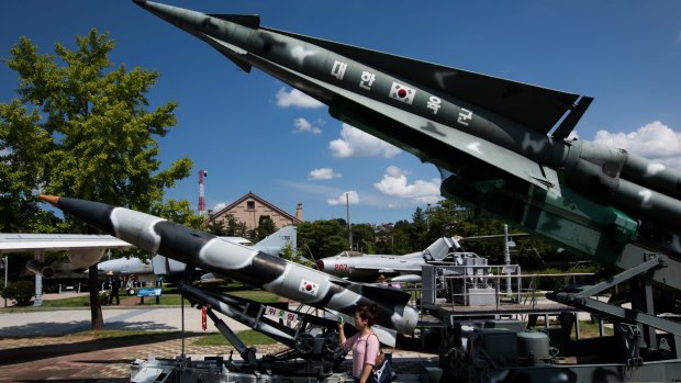 A visitor takes photographs next to a mock MIM 14 Nike Hercules surface-to-air missile, right, and other missiles on display at the War Memorial of Korea museum in Seoul, South Korea.