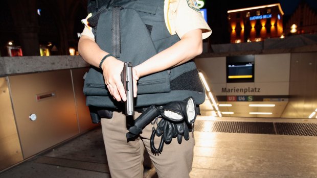 An armed policewoman guards the entrance to Marienplatz underground station following a shooting in the city on Friday evening.