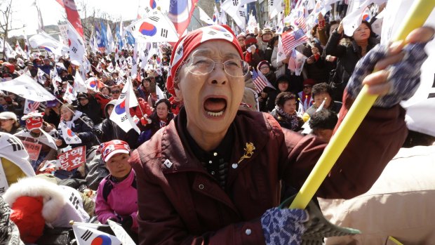 A supporter of South Korean President Park Geun-hye cries during a rally opposing her impeachment near the Constitutional Court in Seoul, South Korea, on Friday