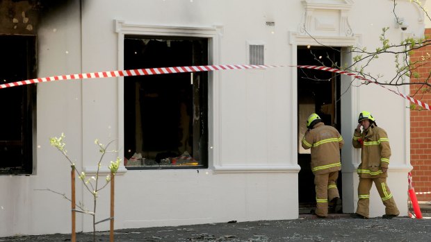 Firefighters enter the burnt-out hotel the day after the fire.