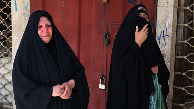 Women grieve at the site of a deadly bomb attack, in Baghdad, Iraq.