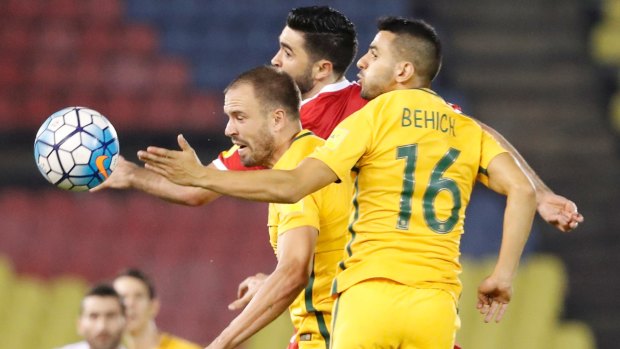 Giving teams a chance: Aziz Behich and Matthew Jurman fight for control of the ball with Syria's Omar Alsoma.