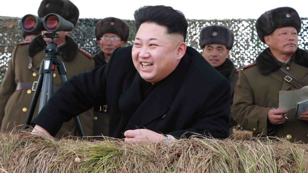 North Korean leader Kim Jong-un laughs as he watches a winter river-crossing attack drill.