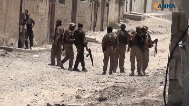 This frame grab from video released by Hawar News Agency, a Syrian Kurdish activist-run media group, shows US-backed Syrian Democratic Forces fighters in Raqqa, Syria, on Thursday.