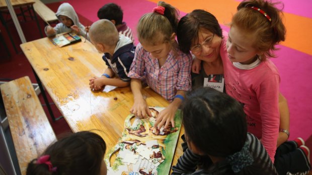 Barbara, a volunteer, plays with refugee children at the Berliner Messe trade fair grounds in Berlin on Thursday.