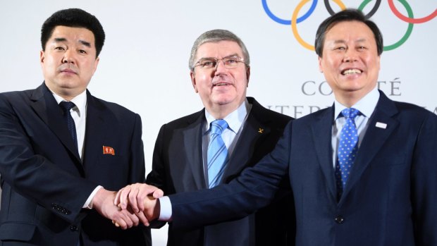 Show of unity: IOC president shakes hands with North and South Korean ministers. 