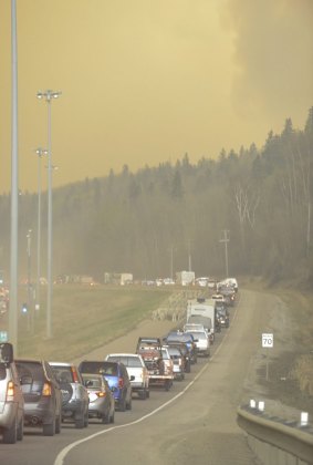 Smoke fills the air as people leave Fort McMurray, Alberta,  by road.