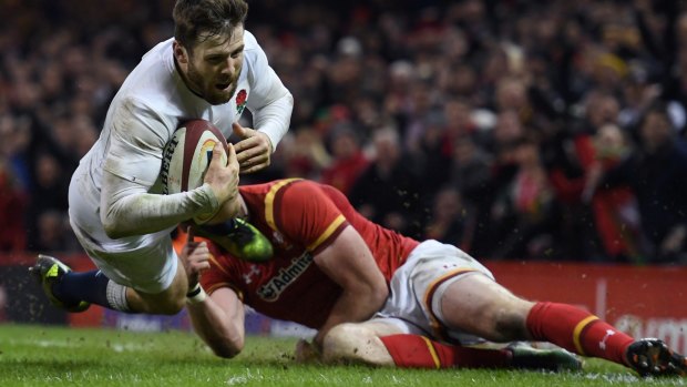 Match-winner: Elliot Daly of England dives past Alex Cuthbert of Wales to score the decisive try.