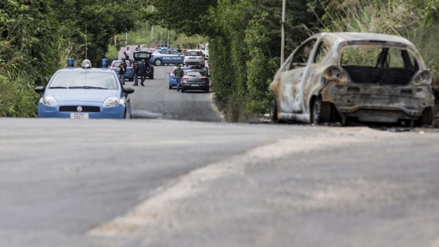 The burned car belonging to slain 22-year-old student Sara Di Pietrantonio is seen along a street in the outskirts of Rome.