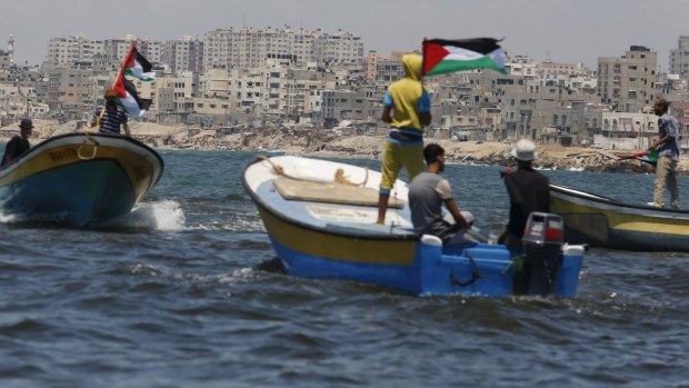 Palestinians riding boats hold Palestinian flags during a protest against the Israeli blocking of a boat of foreign activists from reaching Gaza, at the Seaport of Gaza City on Monday.