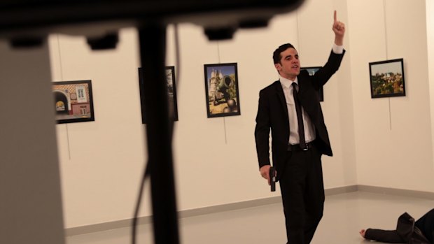 A man with a gun shouts inside the Ankara gallery as Russian ambassador to Turkey Andrei Karlov lies on the ground.