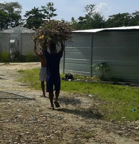 Men inside the now-closed Manus Island regional processing facility collecting firewood.