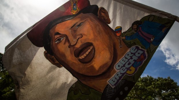 A supporter waves a flag displaying the image of late Venezuelan president Hugo Chavez during a pro-government rally against US President Donald Trump in Caracas.