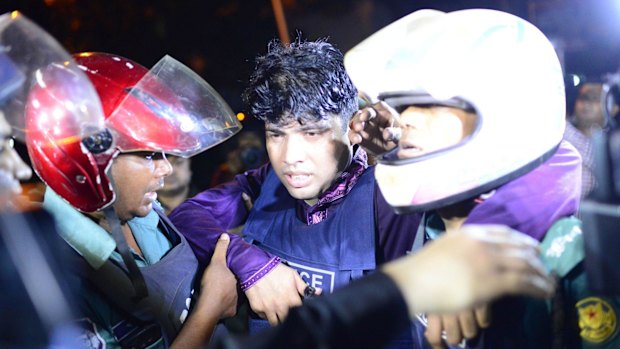 An injured Bangladeshi policeman being assisted after the attack.