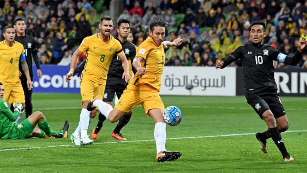 Patience please: Mark Milligan of the Socceroos strikes the ball but fails to break through against Thailand.