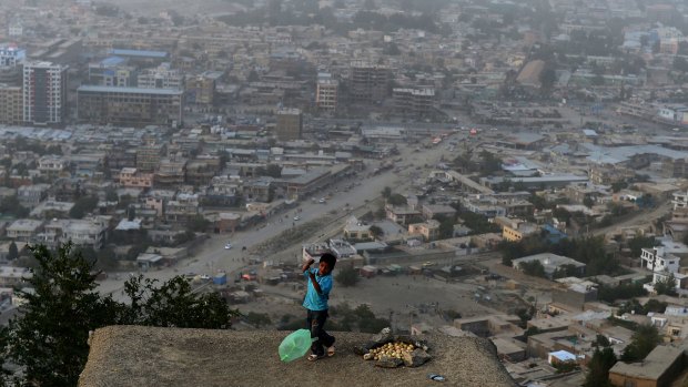 An Afghan boy plays on a rooftop overlooking Kabul. Aid to Afghanistan is heavily dependent on a democratic transition.