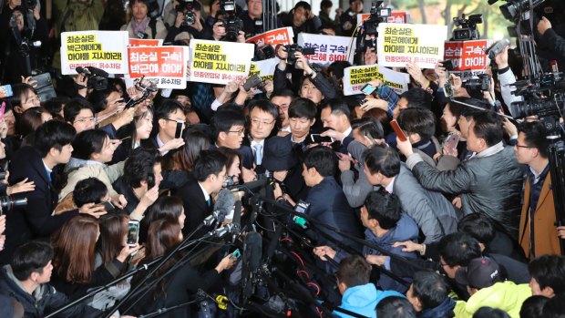 Choi Soon-sil, centre wearing a hat, a cult leader's daughter with a decades-long connection to President Park Geun-hye, is questioned by media at the Seoul Central District Prosecutors' Office.