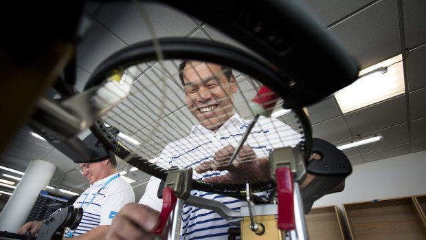 Stringer Shinji Nakamura, who has been a contractor for the past seven years, re-stringing a racquet.