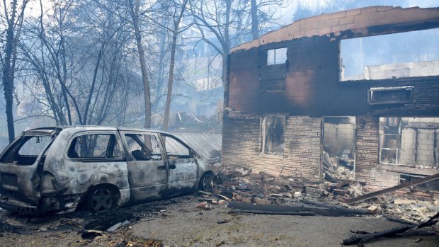 A home and vehicle are damaged from the wildfires around Gatlinburg, Tennessee.