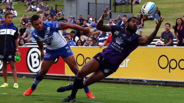 Latching on: Marika Koroibete gets to the ball ahead of Sam Perrett during the NRL trial between the Canterbury Bulldogs and the Melbourne Storm at Belmore Sports Ground.
