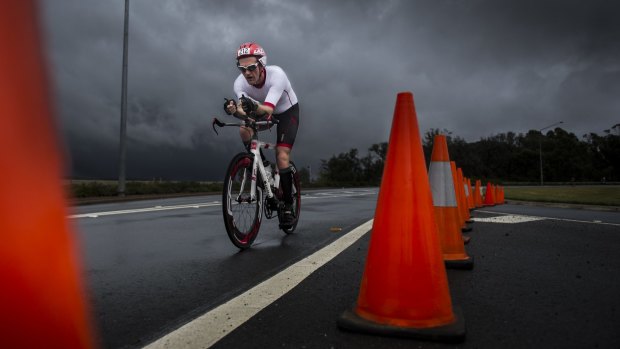 Threatening weather: A competitor takes part in the November Fest triathlon on Sunday as more dark clouds loom.