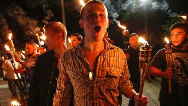 White nationalist groups march with torches through a university campus in Charlottesville.