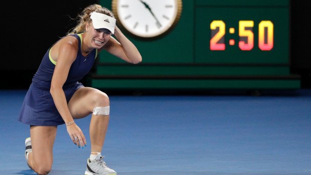 Caroline Wozniacki celebrates after defeating Simona Halep with the clock in the background indicating the epic contest.