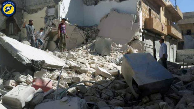 In a picture provided by the Syrian Civil Defence group, Syrians inspect damaged buildings after air strikes hit the Bustan al-Qasr neighbourhood of Aleppo.