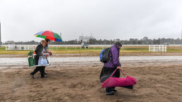 You bet these punters are prepared for gloomy conditions at Flemington on Melbourne Cup Day.