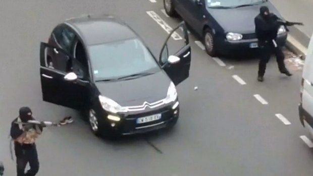 Gunmen flee the offices of French satirical newspaper <i>Charlie Hebdo</i>.