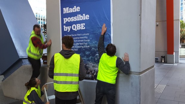 Eight activists pasted images of damaged coral reef and major fuel projects at QBE's headquarters in Sydney. 