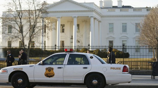 Members of the US Secret Service keep watch at the fence surrounding the White House in Washington. 