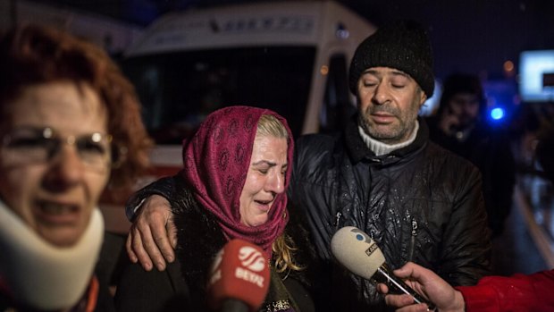 Relatives of victims gather near the club Reina. 