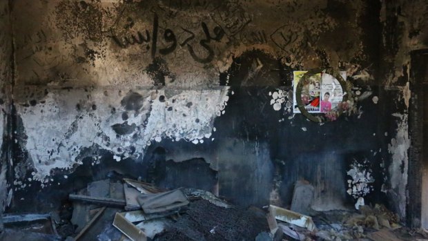 A child's burnt clothing and belongings can still be seen on the floor of the Dawabshe family home. Ali Dawabshe's name is written in Arabic on the wall.