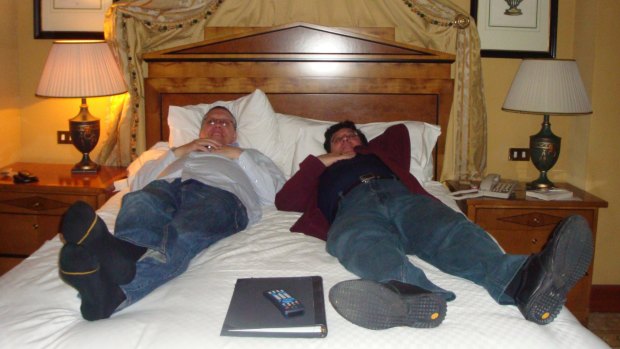 Former Education Department officials Jeff Rosewarne and Nino Napoli on a hotel bed in London.
