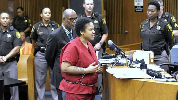 Mitchelle Blair is surrounded by Wayne County Sheriff's deputies and commanders as she addresses the court before her sentencing, Friday, July 17, 2015, in Detroit. Declaring a "house of horrors" closed, a judge sentenced the Detroit mother to life in prison Friday for killing two of her four children and storing their bodies for years in a home freezer. (Todd McInturf/Detroit News via AP)  DETROIT FREE PRESS OUT; HUFFINGTON POST OUT; MANDATORY CREDIT