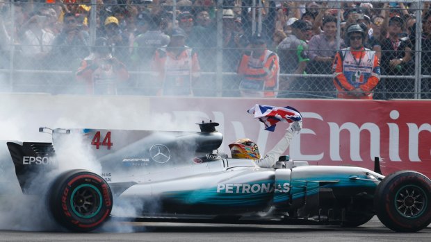 British driver Lewis Hamilton spins his car as he celebrates.