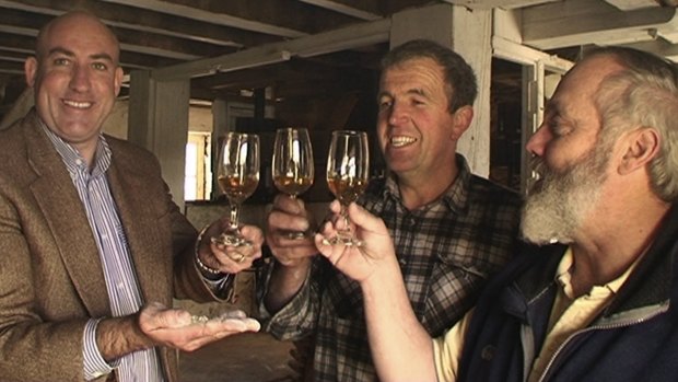 Nant founder Keith Batt, millwright Peter Bignell and master distiller Bill Lark in happier times,  toasting The Nant Distillery in front of the century-old millwheel, which  grinds the farm-grown Franklin barley. Mr Batt filed for bankruptcy in December owing debts of $16 million from his property empire.
