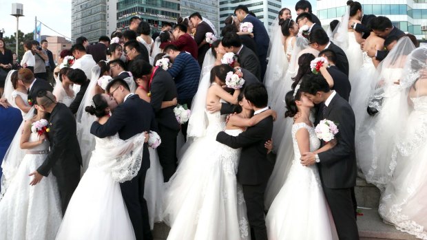 Chinese couples in group wedding ceremony in  South Korea. By 2020, there are expected to be 30 million unmarried Chinese men.