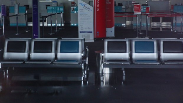 Water pools on the floor near the Qantas and Pelican check-in desks.
