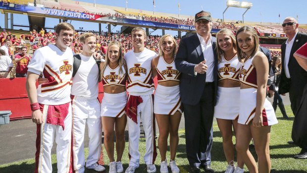 Standing out in the crowd: Donald Trump poses for a photo with Iowa State cheerleaders.