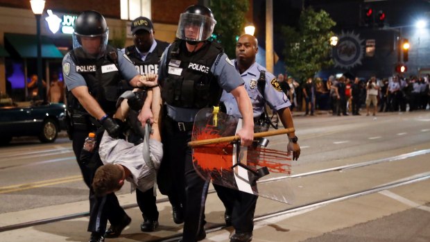 Police arrest a man as they try to clear a violent crowd in University City.