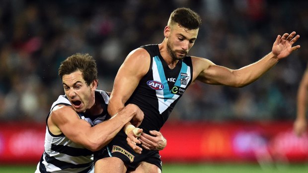 Homecoming: Daniel Menzel tackles Port Adelaide's Jimmy Toumpas. It was Menzel's first game in Adelaide in nearly five years.