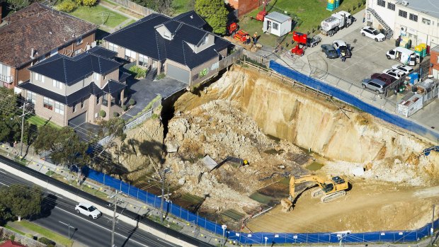 Two townhouses sit on the edge of a crumbling construction pit on the corner of Huntingdale and Highbury Roads, Mount Waverley. All practitioners involved are under investigation.