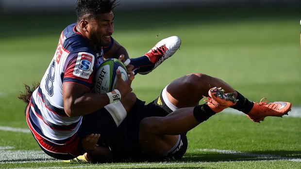 Down for the count: Amanaki Mafi of the Melbourne Rebels is tackled against the Hurricanes.