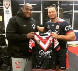 Gift: Thomas is presented with a Roosters guernsey by Boyd Cordner.