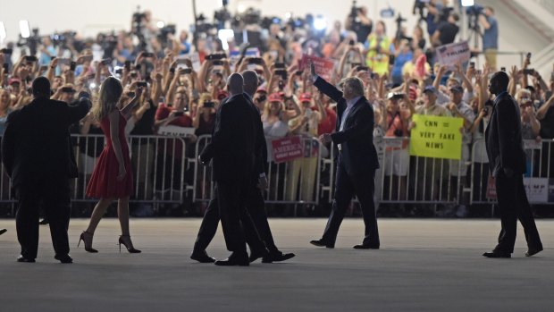 President Donald Trump, second from right, and first lady Melania Trump, third from left, wave to the crowd following the "Make America Great Again Rally" at Orlando-Melbourne International Airport in Melbourne, Florida.