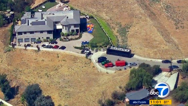 This image from aerial video provided by KABC-TV shows the home of entertainer Chris Brown with a police vehicle outside, in the Tarzana area of Los Angeles.